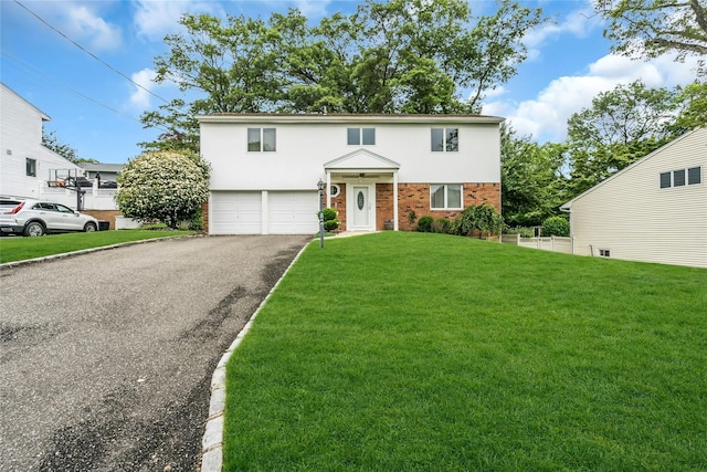185 Harvard Dr, Plainview, NY 11803 - traditional home with brick siding, an attached garage, driveway, a front yard, and stucco siding