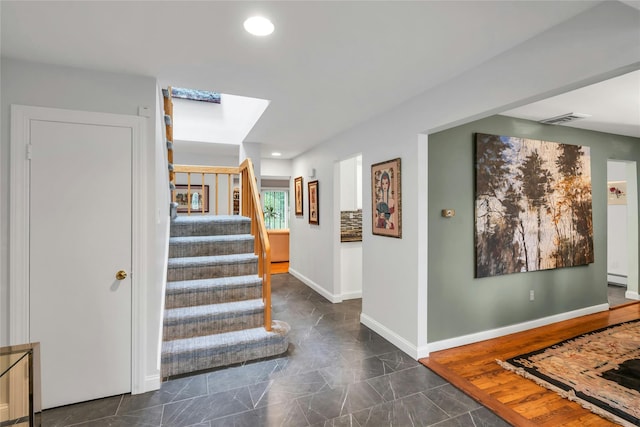 185 Harvard Dr, Plainview, NY 11803 - stairs featuring a skylight, a baseboard heating unit, recessed lighting, and marble finish floors