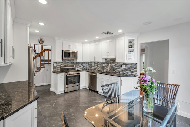 185 Harvard Dr, Plainview, NY 11803 - kitchen with stainless steel appliances, backsplash, white cabinets, recessed lighting, and dark stone countertops