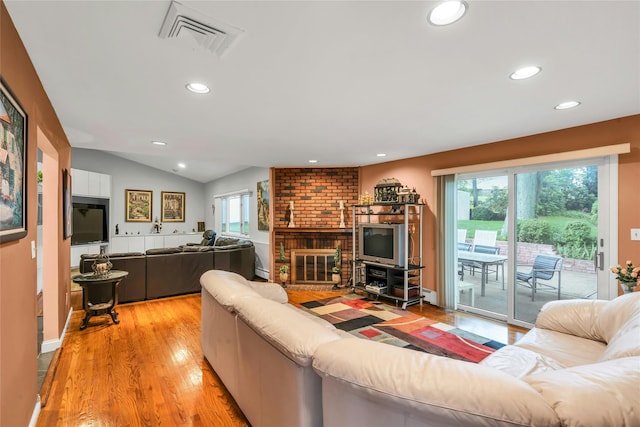 185 Harvard Dr, Plainview, NY 11803 - living area featuring recessed lighting, light wood-type flooring, a brick fireplace, lofted ceiling, and baseboard heating