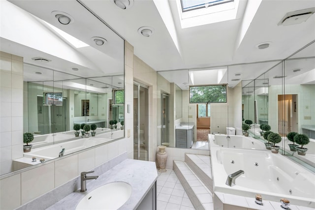 185 Harvard Dr, Plainview, NY 11803 - bathroom featuring a skylight, a shower stall, a jetted tub, vanity, and tile walls