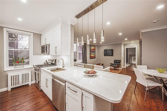 1133 Midland Ave Unit 4C, Bronxville, NY 10708 - kitchen featuring appliances with stainless steel finishes, ornamental molding, a peninsula, white cabinets, and open floor plan