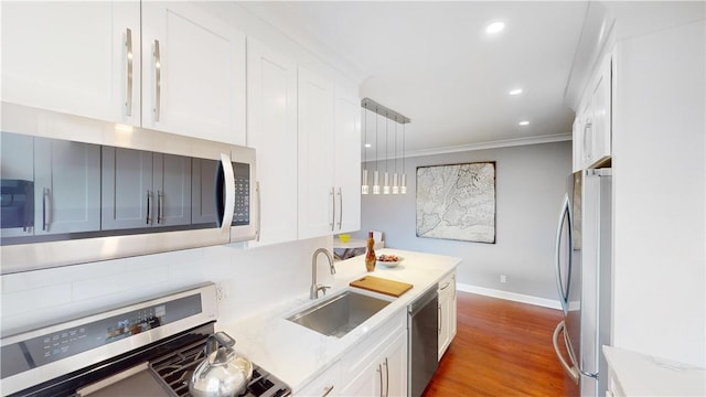 1133 Midland Ave Unit 4C, Bronxville, NY 10708 - kitchen featuring stainless steel appliances, white cabinets, recessed lighting, wood finished floors, and crown molding