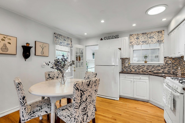 15 Robbins Ave, Islip, NY 11751 - kitchen with white appliances, light wood-type flooring, white cabinets, backsplash, and dark stone countertops