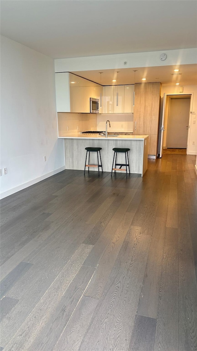 131-05 40th Rd Unit 11H, Flushing, NY 11354 - kitchen with stainless steel microwave, modern cabinets, dark wood-style floors, white cabinets, and recessed lighting