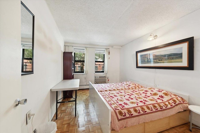 1901 Madison Ave Unit 105, New York Manhattan, NY 10035 - bedroom featuring a textured ceiling, a baseboard radiator, and a wall mounted air conditioner