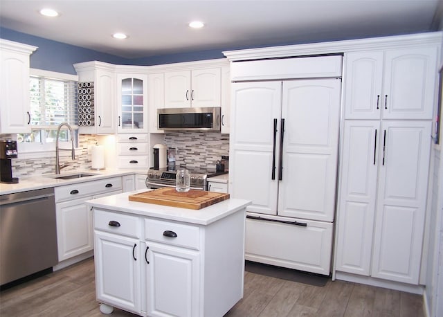 4 Bowman Ln, Commack, NY 11725 - kitchen featuring stainless steel appliances, light wood-style floors, decorative backsplash, white cabinets, and recessed lighting