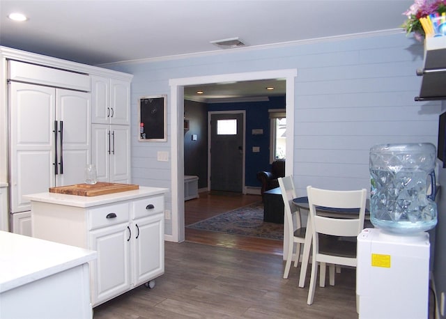 4 Bowman Ln, Commack, NY 11725 - kitchen with paneled fridge, crown molding, dark wood-style floors, white cabinetry, and light countertops