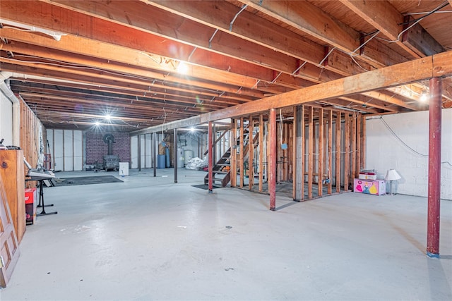 2136 Rte 55, Lagrangeville, NY 12540 - unfinished basement featuring stairway, electric water heater, and a wood stove