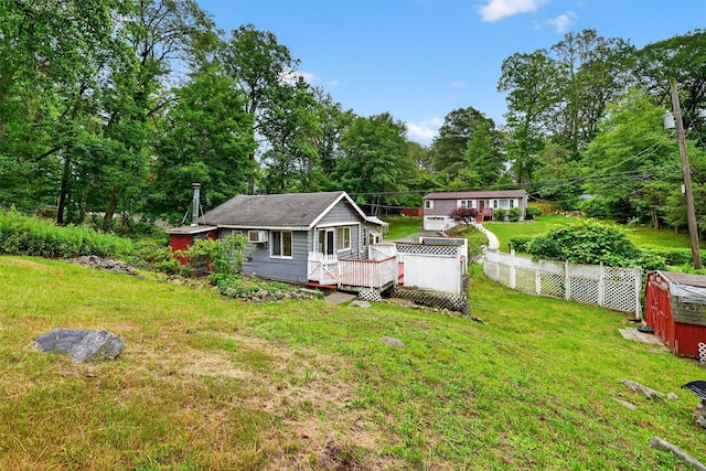 9 Mimosa St, Lake Peekskill, NY 10537 - back of house with a deck, view of wooded area, and a storage shed