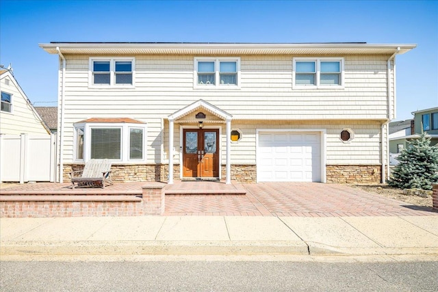 755 E Chester St, Long Beach, NY 11561 - view of front of home with stone siding, a garage, and decorative driveway