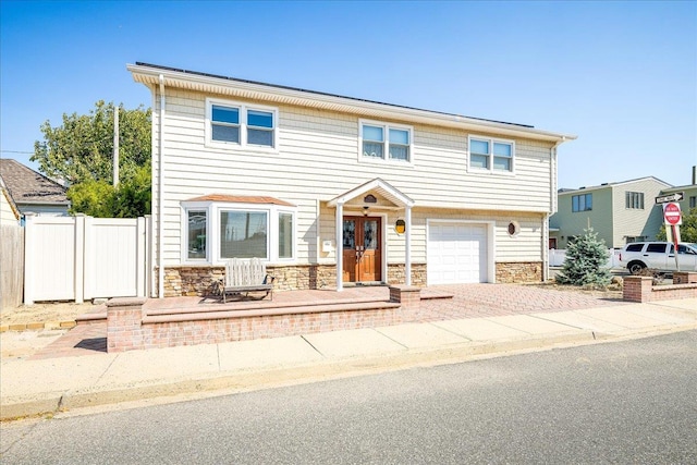 755 E Chester St, Long Beach, NY 11561 - view of front of property featuring stone siding, an attached garage, and decorative driveway