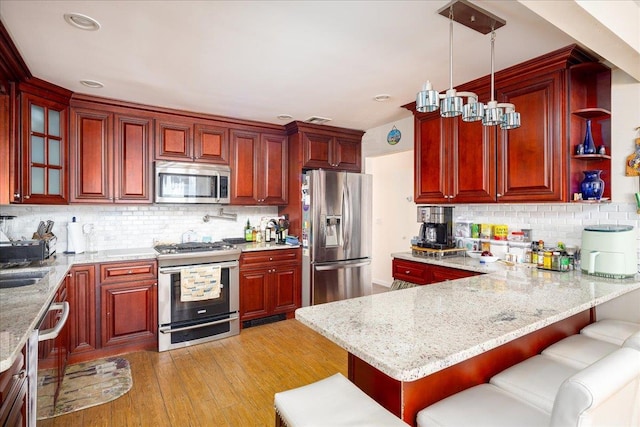 755 E Chester St, Long Beach, NY 11561 - kitchen featuring stainless steel appliances, dark brown cabinets, light wood-style floors, a peninsula, and recessed lighting