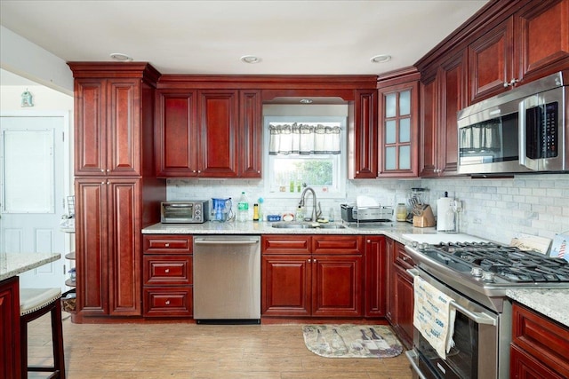 755 E Chester St, Long Beach, NY 11561 - kitchen with stainless steel appliances, reddish brown cabinets, tasteful backsplash, and recessed lighting