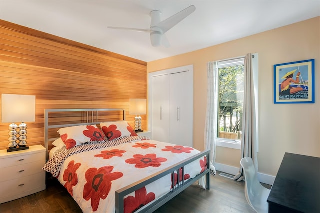 172 Pine Walk, Fire Island Pines, NY 11782 - bedroom with wooden walls, dark wood-style flooring, a closet, and a ceiling fan