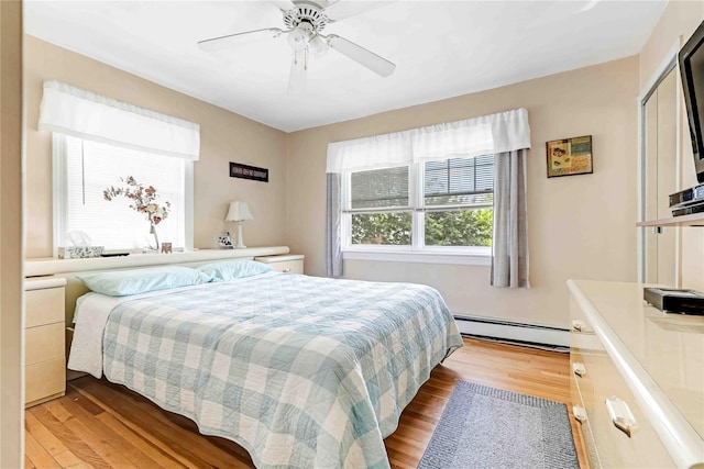 4911 168th St, Flushing, NY 11365 - bedroom featuring baseboard heating, light wood-style floors, and a ceiling fan