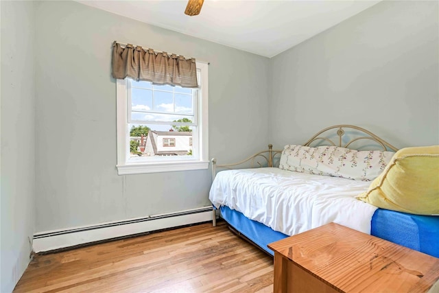 4911 168th St, Flushing, NY 11365 - bedroom featuring baseboard heating, light wood-style flooring, and a ceiling fan