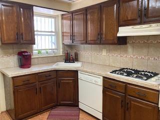 5855 41st Dr, Woodside, NY 11377 - kitchen featuring white appliances, under cabinet range hood, light countertops, and backsplash