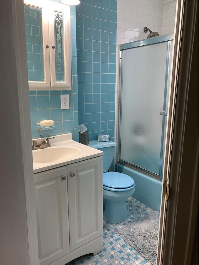5855 41st Dr, Woodside, NY 11377 - full bath with tile walls, tile patterned floors, vanity, and combined bath / shower with glass door