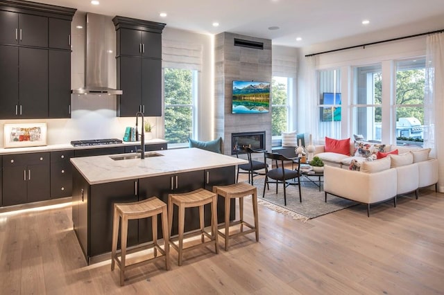 4039 Fairways Dr Unit 120, Carmel, NY 10512 - kitchen with wall chimney exhaust hood, open floor plan, light wood-type flooring, an island with sink, and recessed lighting