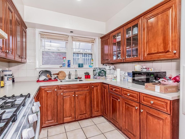 1405 E 233rd St, Bronx, NY 10466 - kitchen with black microwave, tasteful backsplash, white gas stove, glass insert cabinets, and light countertops