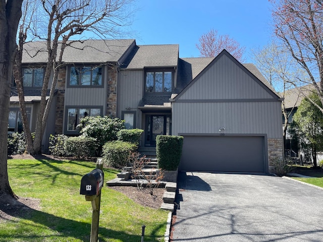 133 Woodbrook Rd, White Plains, NY 10605 - view of front of house with asphalt driveway, stone siding, roof with shingles, an attached garage, and a front lawn