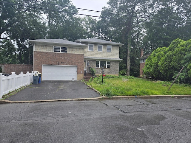 28 Brookdale Rd, Glen Cove, NY 11542 - view of front facade with asphalt driveway, a garage, and view of wooded area
