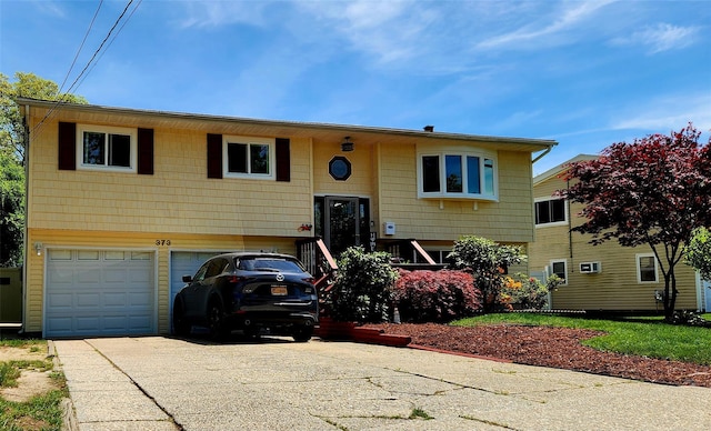 373 Commack Rd, Islip, NY 11751 - split foyer home featuring concrete driveway and an attached garage