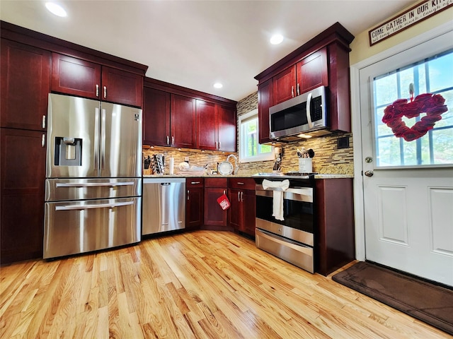 373 Commack Rd, Islip, NY 11751 - kitchen featuring stainless steel appliances, dark brown cabinets, light wood-style flooring, backsplash, and light stone counters