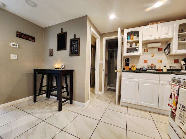 373 Commack Rd, Islip, NY 11751 - kitchen featuring white cabinets, glass insert cabinets, backsplash, and dark countertops