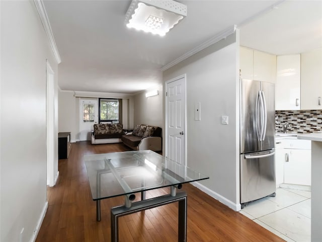 61-25 98th St Unit 2H, Rego Park, NY 11374 - kitchen with freestanding refrigerator, crown molding, tasteful backsplash, light wood-style floors, and white cabinets