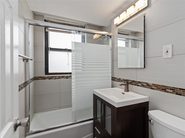 61-25 98th St Unit 2H, Rego Park, NY 11374 - bathroom with tile walls, shower / bath combination with glass door, vanity, and decorative backsplash