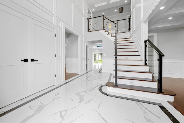 71 Cedar St, Hicksville, NY 11801 - staircase featuring a decorative wall, inlaid floor details, marble tiled flooring, recessed lighting, and a high ceiling