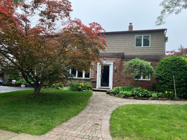 99 Stone Ln, Levittown, NY 11756 - view of front of home featuring brick siding, a front yard, and a chimney