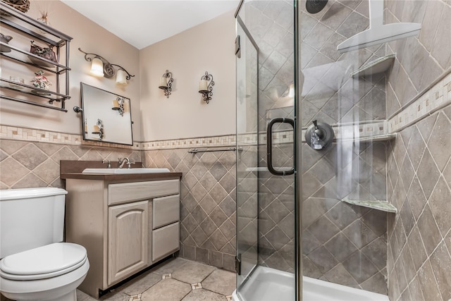 99 Stone Ln, Levittown, NY 11756 - bathroom with tile walls, vanity, a shower stall, tile patterned floors, and a wainscoted wall