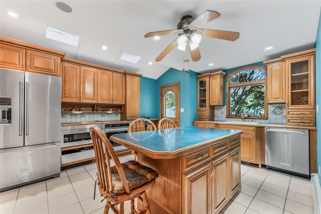 99 Stone Ln, Levittown, NY 11756 - kitchen with appliances with stainless steel finishes, backsplash, lofted ceiling, a skylight, and a ceiling fan