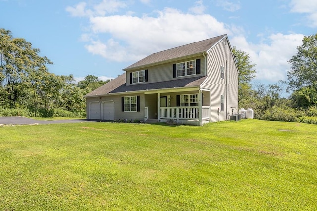 284 W Mombasha Rd, Monroe, NY 10950 - view of front facade with covered porch, asphalt driveway, a garage, and a front lawn