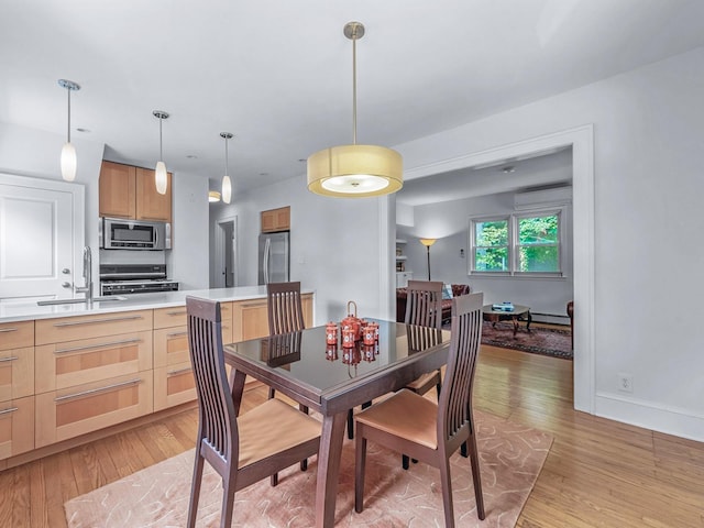 20 Fairmount Blvd, Garden City, NY 11530 - dining area featuring light wood-style flooring, a wall mounted air conditioner, and a baseboard radiator