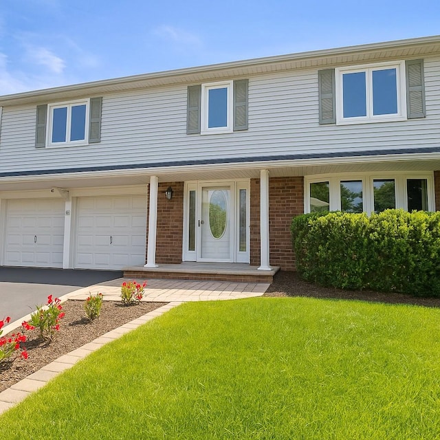61 Sherwood Ct, Huntington, NY 11743 - view of front of home with a front lawn, a garage, brick siding, and concrete driveway
