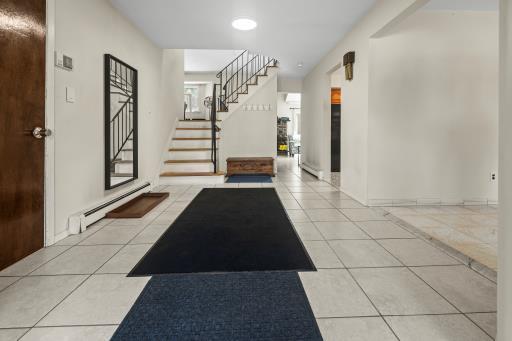 61 Sherwood Ct, Huntington, NY 11743 - tiled foyer entrance featuring stairway, a baseboard heating unit, and recessed lighting