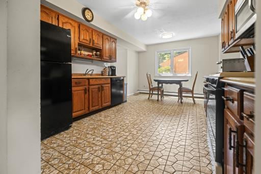 61 Sherwood Ct, Huntington, NY 11743 - kitchen with black appliances, brown cabinetry, light countertops, and a baseboard radiator