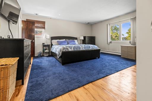 61 Sherwood Ct, Huntington, NY 11743 - bedroom featuring a baseboard radiator, multiple windows, and wood finished floors