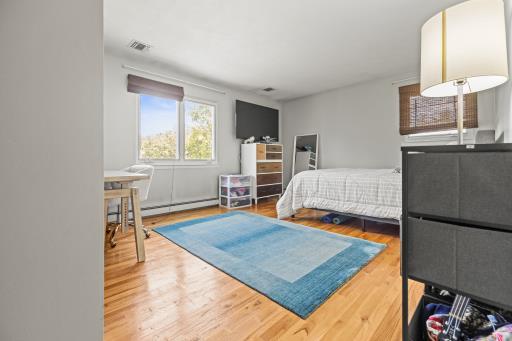 61 Sherwood Ct, Huntington, NY 11743 - bedroom featuring a baseboard heating unit and wood finished floors