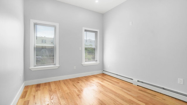 506 E 183rd St, Bronx, NY 10458 - unfurnished room featuring a baseboard heating unit, healthy amount of natural light, and wood finished floors