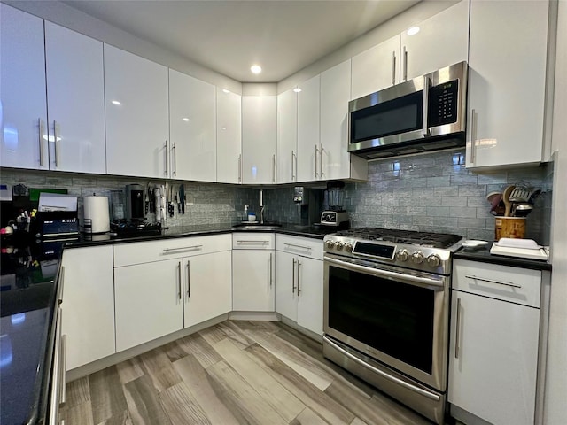 87-14 57th Rd Unit 1A, Elmhurst, NY 11373 - kitchen featuring appliances with stainless steel finishes, white cabinets, dark countertops, and tasteful backsplash