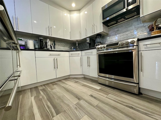 87-14 57th Rd Unit 1A, Elmhurst, NY 11373 - kitchen with appliances with stainless steel finishes, white cabinets, dark countertops, light wood finished floors, and recessed lighting