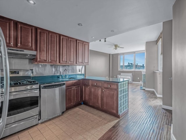 13338 Sanford Ave Unit 9G, Flushing, NY 11355 - kitchen with stainless steel appliances, under cabinet range hood, a peninsula, a ceiling fan, and dark countertops