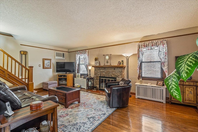 163-50 25th Dr, Flushing, NY 11358 - living area with a textured ceiling, wood finished floors, an AC wall unit, a textured wall, and stairway