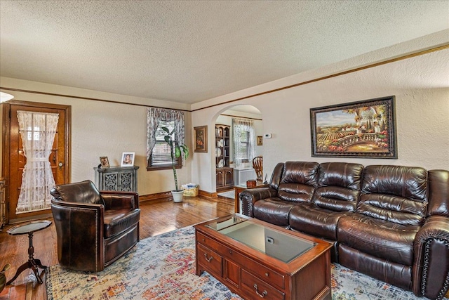 163-50 25th Dr, Flushing, NY 11358 - living room with arched walkways, a textured ceiling, wood finished floors, healthy amount of natural light, and a textured wall