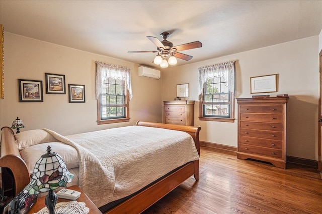 163-50 25th Dr, Flushing, NY 11358 - bedroom with a wall unit AC, multiple windows, wood finished floors, and a ceiling fan
